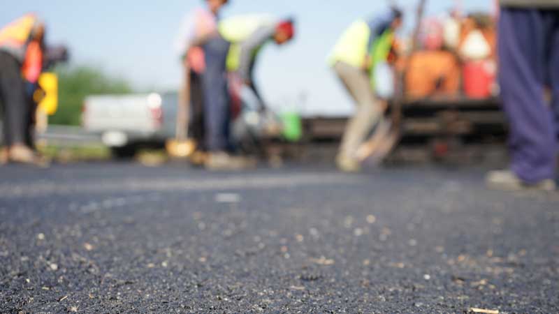 A team of men working on an asphalt paving job